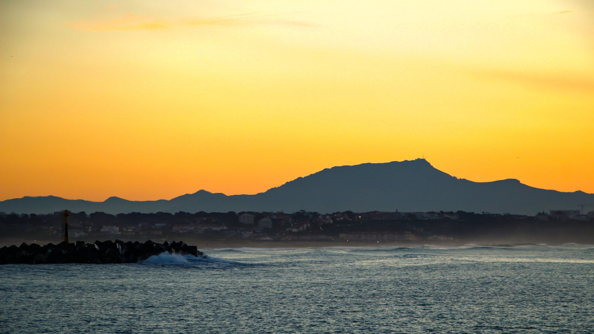 Vue sur les Pyrénées et la montagne de la rhune depuis la digue de Tarnos au coucher de soleil